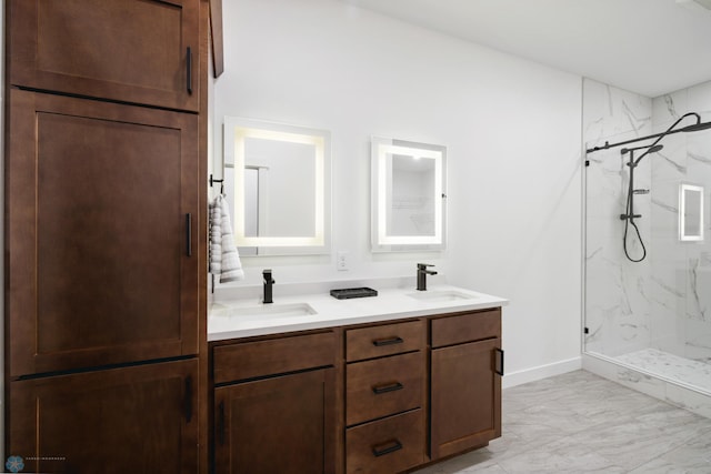 full bath featuring double vanity, marble finish floor, a sink, and a marble finish shower
