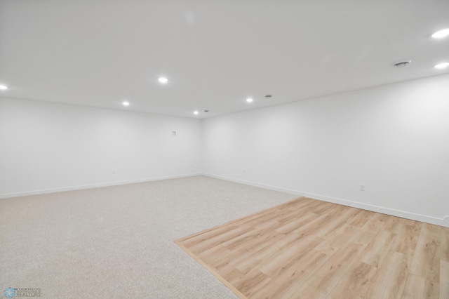 spare room with light carpet, baseboards, and recessed lighting