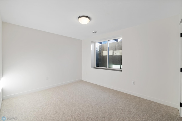 empty room featuring baseboards and carpet floors