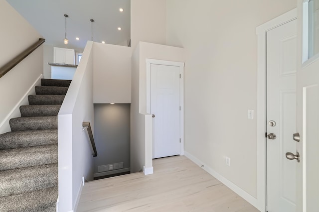 stairs featuring hardwood / wood-style flooring and a high ceiling