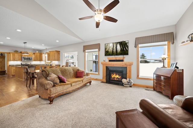 living room featuring vaulted ceiling, light colored carpet, and ceiling fan