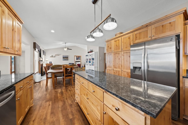 kitchen featuring decorative light fixtures, a center island, vaulted ceiling, appliances with stainless steel finishes, and dark hardwood / wood-style flooring