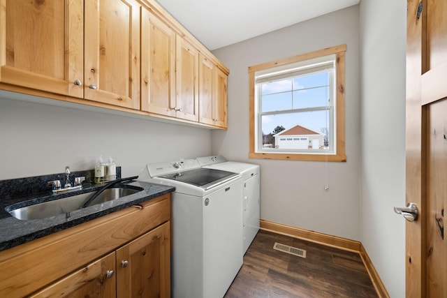 washroom featuring cabinets, dark hardwood / wood-style floors, washer and clothes dryer, and sink