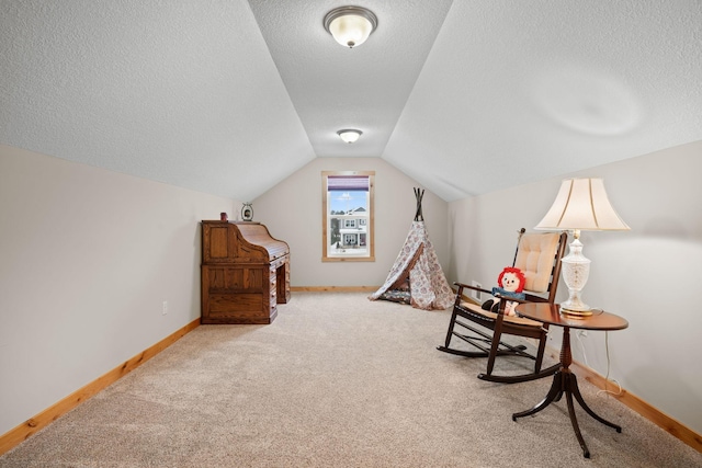 interior space featuring lofted ceiling, light colored carpet, and a textured ceiling