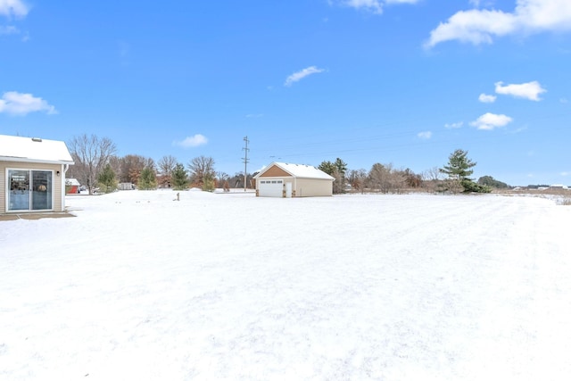 yard layered in snow featuring a garage