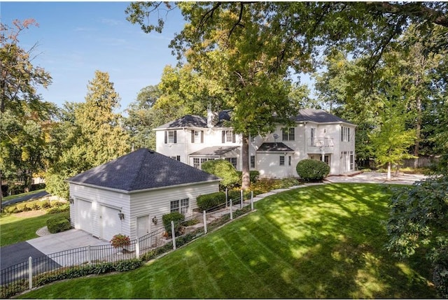 back of house with a garage and a lawn