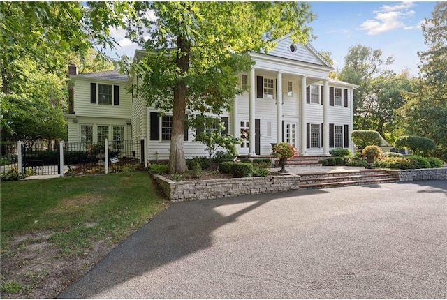 neoclassical / greek revival house featuring a front yard