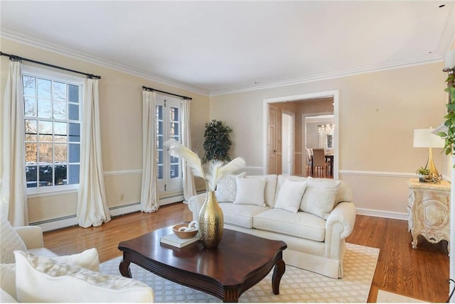 living room with crown molding, a baseboard heating unit, and hardwood / wood-style floors