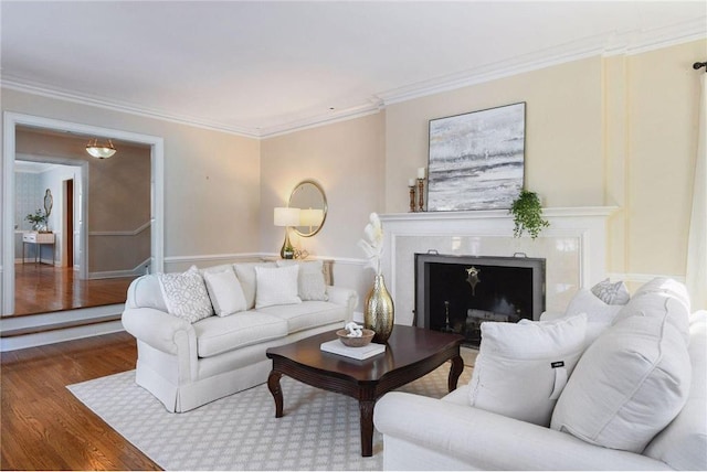 living room with a premium fireplace, wood-type flooring, and ornamental molding