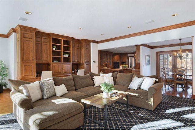 living room with ornamental molding, hardwood / wood-style floors, and a chandelier