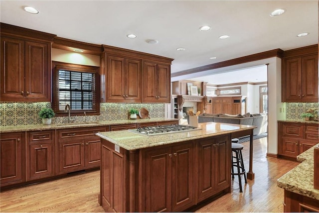 kitchen featuring light stone countertops, sink, and stainless steel gas cooktop