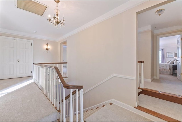 stairway with crown molding, a chandelier, and carpet floors