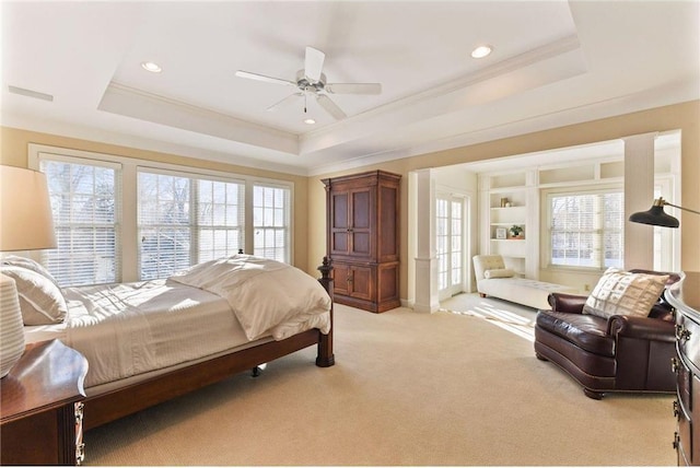 carpeted bedroom featuring a raised ceiling, ornamental molding, and multiple windows