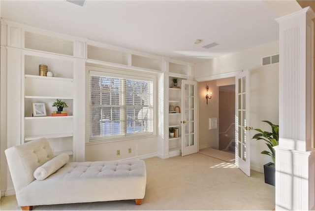 living area featuring light carpet, built in features, and french doors