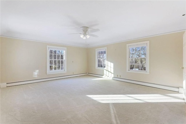 empty room with light colored carpet, a baseboard radiator, ornamental molding, and ceiling fan