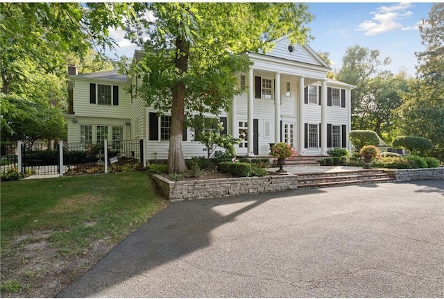 neoclassical home featuring a front yard