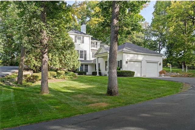 colonial-style house with a garage and a front lawn