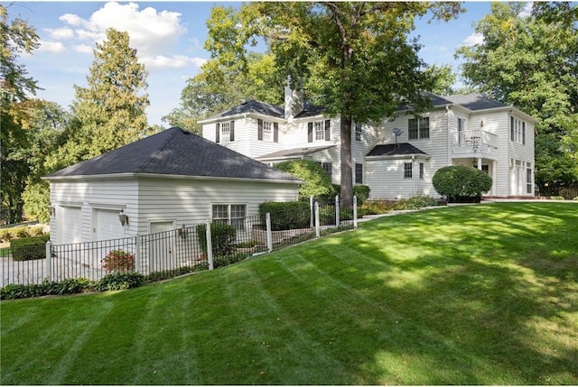 back of property with a garage and a lawn