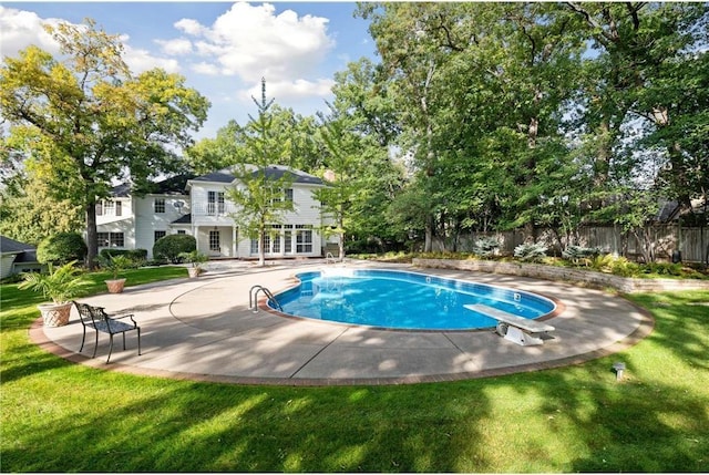 view of pool with a patio, a diving board, and a lawn