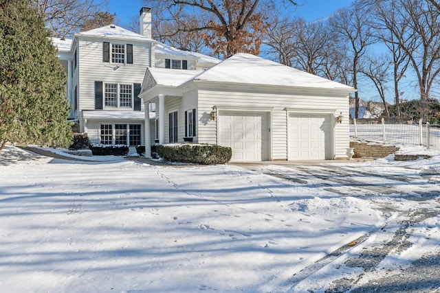 snow covered property with a garage