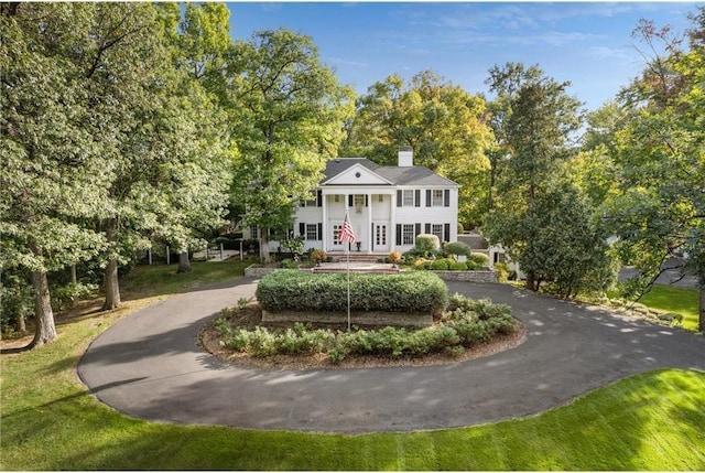 view of front of home featuring curved driveway and a chimney