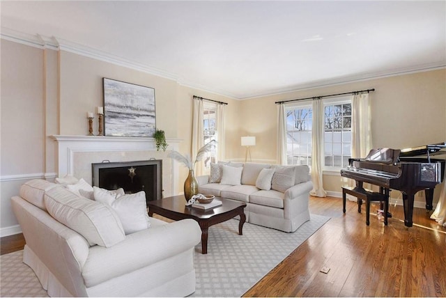 living area featuring baseboards, crown molding, wood finished floors, and a wealth of natural light