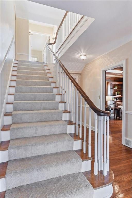 stairs with visible vents and wood finished floors