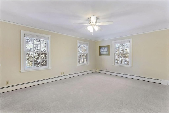 carpeted empty room with a healthy amount of sunlight, ornamental molding, baseboard heating, and a ceiling fan