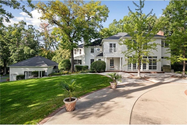 view of front of home featuring a chimney, french doors, and a front yard