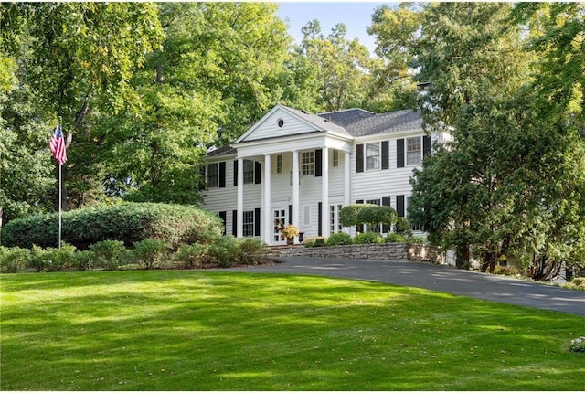 greek revival house with a front lawn and driveway