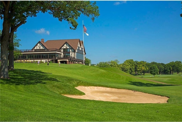 surrounding community featuring a lawn, a deck, and golf course view