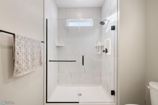 bathroom with walk in shower and toilet