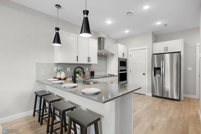 5861 41st St S, Fargo, ND 58104 - kitchen featuring stainless steel appliances, wall chimney exhaust hood, a peninsula, tasteful backsplash, and a breakfast bar