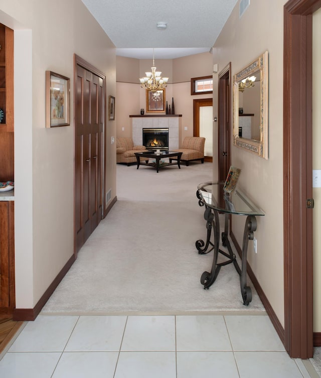 corridor with tile patterned flooring, visible vents, baseboards, and carpet floors