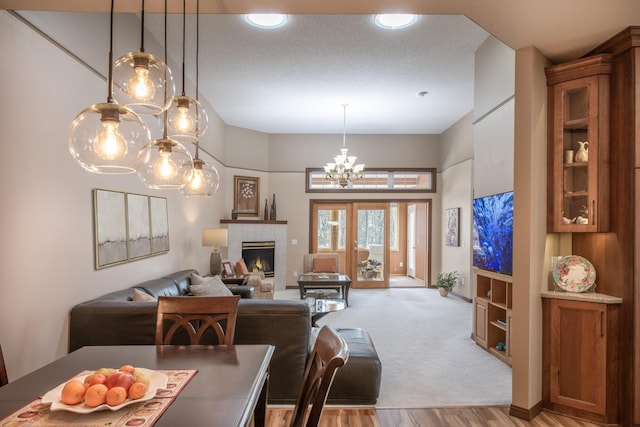 living area with a chandelier, a fireplace, and light wood-style floors