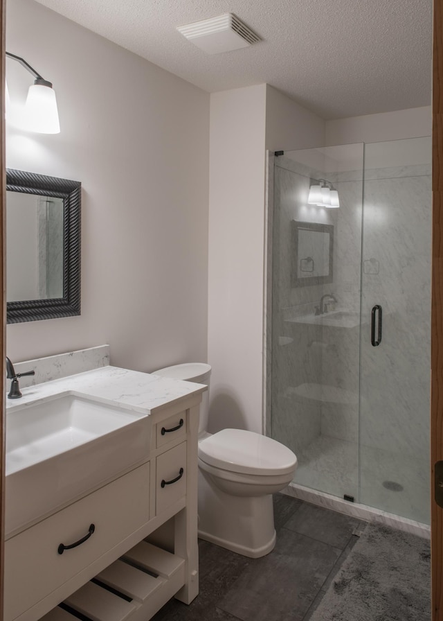 full bathroom with vanity, a shower stall, toilet, and visible vents