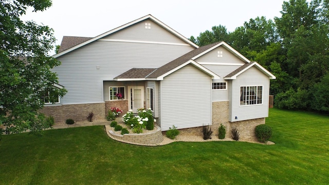 view of front facade with brick siding and a front yard