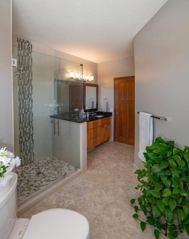 full bathroom with vanity, a notable chandelier, a stall shower, and a textured ceiling