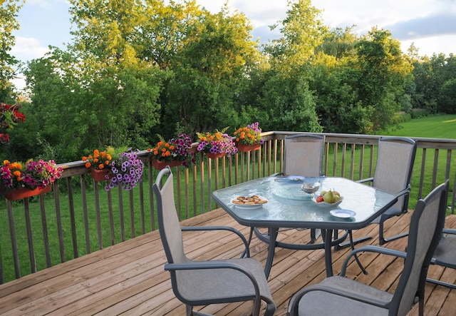 wooden terrace with a lawn and outdoor dining area