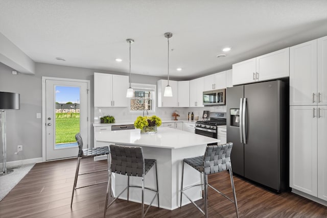 kitchen with pendant lighting, white cabinets, and appliances with stainless steel finishes