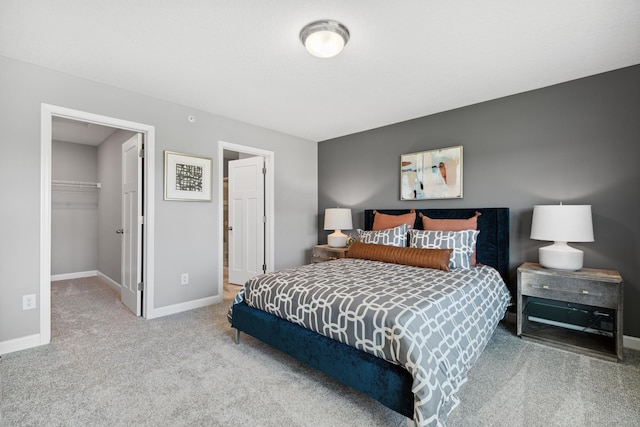 carpeted bedroom featuring a spacious closet and a closet