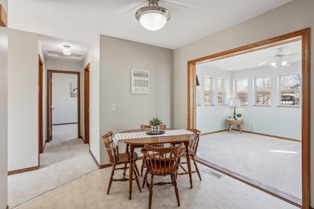 dining room with light floors, visible vents, attic access, light carpet, and baseboards