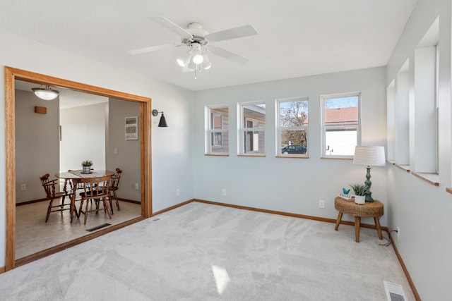 interior space featuring carpet, visible vents, ceiling fan, and baseboards