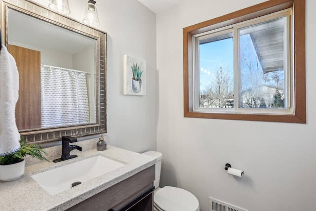 full bathroom with curtained shower, visible vents, vanity, and toilet