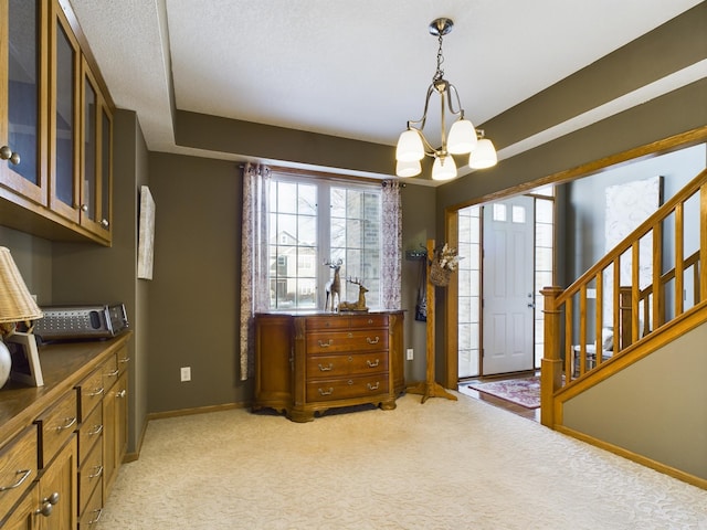 entrance foyer featuring light carpet, stairway, a chandelier, and baseboards