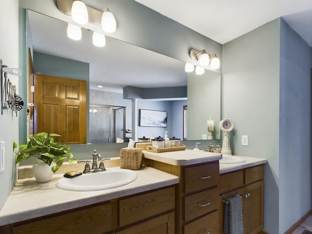 full bath featuring double vanity, a stall shower, and a sink