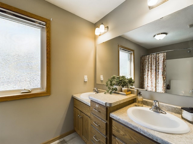 full bathroom with visible vents, vanity, and baseboards