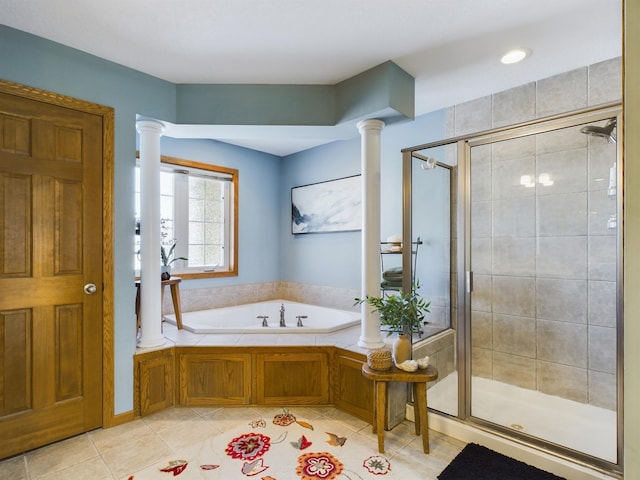 full bath with a garden tub, tile patterned floors, a shower stall, and ornate columns