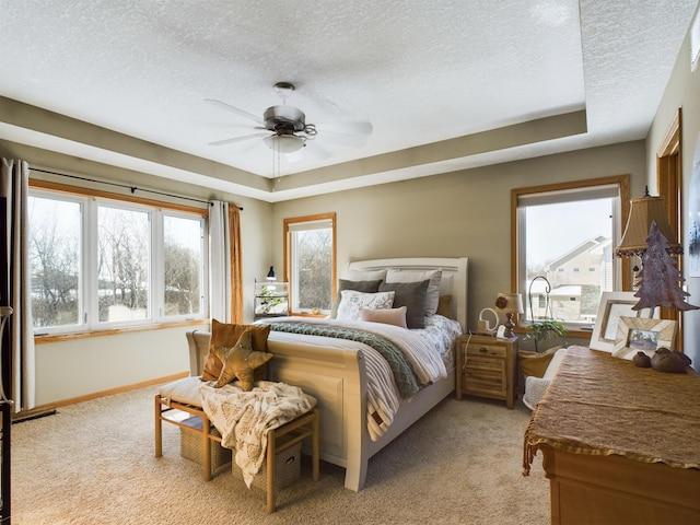 bedroom with light carpet, ceiling fan, a textured ceiling, and baseboards