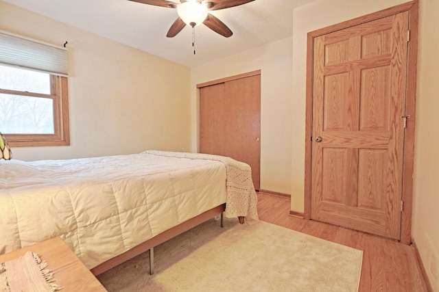 bedroom with ceiling fan, a closet, and light hardwood / wood-style flooring